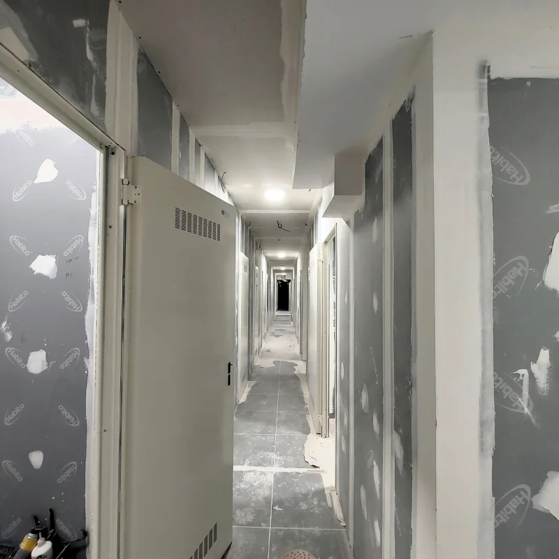 Pasillo de trasteros terminados con sistemas de tabiquería seca de alta resistencia Placa Habito