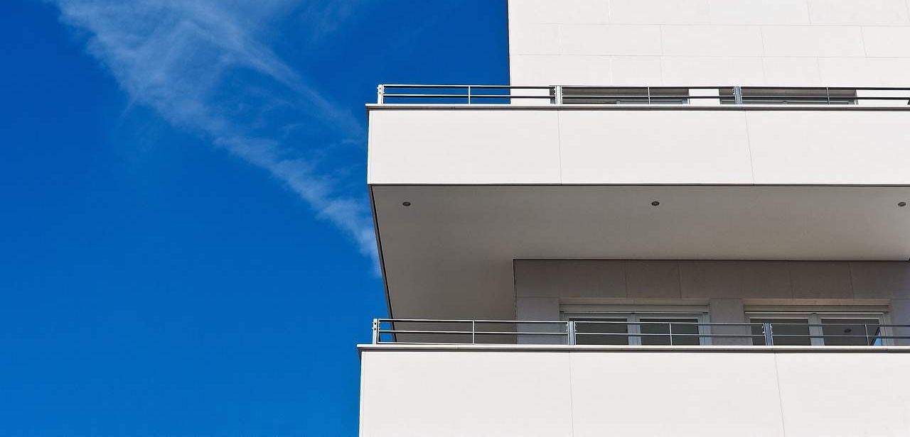 Salón moderno con flujo de aire fresco a través de ventanas abiertas que representan una ventilación eficiente y saludable en una vivienda.